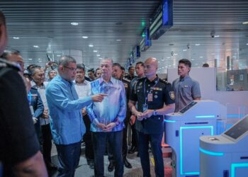 FADILLAH Yusof meninjau di pintu masuk dengan melihat sistem kod respons pantas (QR) selepas Majlis Peluncuran Agensi Kawalan Dan Perlindungan Sempadan Malaysia, di KLIA Terminal. -UTUSAN/FAIZ ALIF ZUBIR