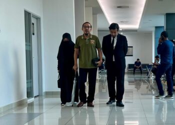 TERTUDUH (tengah) berjalan masuk ke mahkamah bagi menghadapi lima pertuduhan kes amang seksual ke atas dua pelajar di Kompleks Mahkamah Kangar, Perlis, hari ini.-UTUSAN/ASYRAF MUHAMMAD