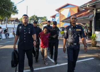 YUSOOFF Salleh dikawal anggota polis selepas berdepan pertuduhan melakukan ugutan bunuh terhadap lima remaja dan melepaskan tembakan di tempat tidak dibenarkan di Mahkamah Majistret Kuala Nerang di Padang Terap, hari ini. - UTUSAN/SHAHIR NOORDIN
