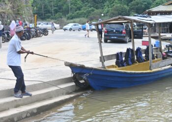 HUSIN Sulaiman setia membawa bot penambang dan perahu gentian kaca yang merupakan sumber pendapatan keluarganya di Kuala Tahan di Jerantut, Pahang. – UTUSAN/SHAIKH AHMAD RAZIF