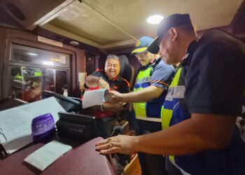MOHD. Misuari Abdullah(dua kanan) bersama pegawai memeriksa buku log perjalanan bas semasa Ops Khas Tahun Baharu Cina di Stesen JPJ Bukit Jawa, Selising, Pasir Puteh, Kelantan malam tadi-UTUSAN/YATIMIN ABDULLAH.