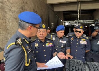 AZMAN Adam, (kiri) bersama Aedy Fadly Ramli (dua kiri) meneliti tayar-tayar celup yang diproses di sebuah premis di Jalan Meranti Jaya, Taman Industri Meranti Permai, Puchong, hari ini.