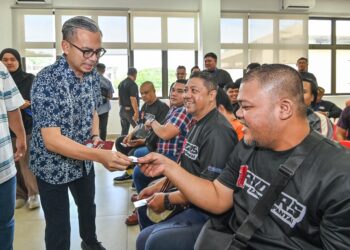 MENTERI Komunikasi, Fahmi Fadzil ketika menyerahkan sumbangan kepada peserta Program Temu Anak Muda Lembah Pantai di sini, hari ini. - UTUSAN/SYAKIR RADIN