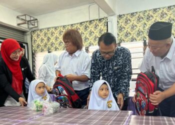ROSE Aza Che Arifin (dua dari kanan) bermesra dengan pasangan kembar tahun satu yang memulakan persekolahan di Sekolah Kebangsaan (SK) Jelempok, Arau, Perlis, hari ini. -UTUSAN/ASYRAF MUHAMMAD