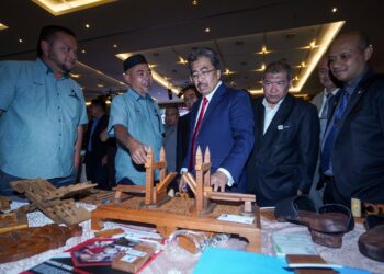 JOHARI Abdul Ghani melawat pameran selepas merasmikan simposium kayu kita pemerkasaaan bumiputera dalam industri perkayuan di Putrajaya. - UTUSAN/FAISOL MUSTAFA