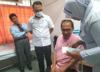 DANIEL Gooi (dua dari kiri) bersama Lim Kim San (dua dari kanan) yang menjadi antara individu terawal menerima vaksin influenza di Klinik Kesihatan Jalan Macalister, George Town, Pulau Pinang, hari ini.