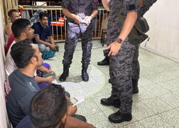 PEGAWAI Imigresen Kuala Lumpur memeriksa dokumen warga asing dalam serbuan di sebuah flat di Chow Kit, pagi tadi.