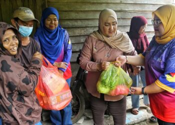 BIBI Sharliza Mohd.Khalid (tiga dari kanan) dan Shahrani Idderis (tiga dari kiri) menyampaikan sumbangan ketika melawat penduduk di Kampung Orang Asli Guntur dan Chergun, Kuala Pilah hari ini.-UTUSAN/ MOHD. SHAHJEHAN MAAMIN.