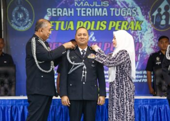 AZRI Ahmad (kiri) memakaikan pangkat jawatan Ketua Polis Perak kepada Noor Hisam Nordin pada majlis serah terima tugas di Ipoh. - UTUSAN/MUHAMAD NAZREEN SYAH MUSTHAFA