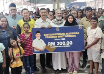 SYED Abu Hussin Hafiz Syed Abdul Fasal (tengah) bersama penerima sumbangan bantuan kembali ke sekolah di Bukit Gantang. - UTUSAN/WAT KAMAL ABAS