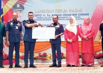 AHMAD Izram Osman (tengah) menyampaikan bantuan kewangan kepada waris pegawai dan kakitangan bomba yang meninggal dunia di Ibu Pejabat Jabatan Bomba dan Penyelamat Malaysia (JBPM) Terengganu di Kuala Terengganu, semalam. - UTUSAN/KAMALIZA KAMARUDDIN