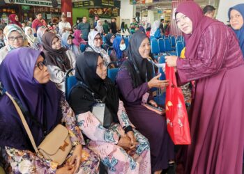 SAPIAH menyampaikan sumbangan duit raya kepada golongan asnaf pada program kebajikan tahunan ‘Masih Ada Yang Sayang’ di Mydin MITC, Ayer Keroh, Melaka, hari ini.