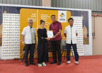 MOHD. JAMIL Idris (kiri) mengiringi Mohd. Noor Helmy Abdul Halem (dua dari kanan) ketika menyampaikan surat tawaran kepada pemohon RMR yang layak di Kompleks Jawatankuasa Pembangunan dan Penyelarasan Dewan Undangan Negeri (Japerun) Duyong, Melaka. - UTUSAN/MUHAMMAD SHAHIZAM TAZALI