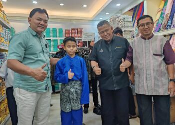 MOHAMAD Azmi Sabtu (dua dari kanan) mengiringi Rahmad Mariman (kiri) menyantuni kanak-kanak penerima sumbangan pakaian raya pada program Tautan Kasih Ramadan Busana Aidilfitri Asnaf di Taman Bukit Piatu Mutiara, Melaka. - UTUSAN/AMRAN ALI