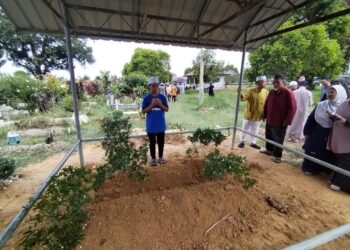 MUHAMAD HAFIY Mohd. Nazri membacakan doa selepas jenazah abang dan bapanya selamat dikebumikan di Tanah Perkuburan Islam Kampung Padang Luas, Besut, Terengganu. 