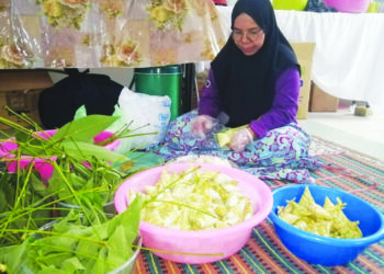 NORIANI Mohd. Nawi menyiapkan ketupat palas yang ditempah pelanggan di rumahnya di Kampung Padang Setengge, Hulu Terengganu. – MINGGUAN/NOOR HAYATI MAMAT