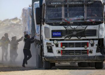 KANAK-kanak Palestin cuba menarik bungkusan bantuan kemanusiaan daripada sebuah trak ketika melalui Rafah di selatan Gaza dari persimpangan Kerem Shalom, pada 18 Februari lepas. – AFP