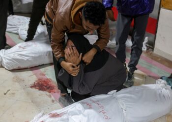 SEORANG wanita Palestin ditenangkan ketika melihat mayat mangsa serangan udara Israel di Hospital Indonesia di Beit Lahia.-AFP