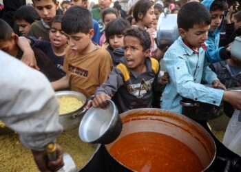 KANAK-kanak Palestin berkumpul untuk mendapatkan hidangan berbuka puasa di pusat pengagihan makanan percuma di kem pelarian Nuseirat di tengah Gaza.- AFP