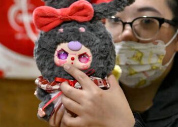 SEORANG penjual menunjukkan anak patung Baby Three dengan tanda di pipinya menyerupai peta tuntutan yang tidak diiktiraf di Laut China Selatan.-AGENSI