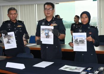 CHRISTOPHER Patit (tengah) menunjukkan gambar motosikal digunakan suspek kes samun pada sidang akhbar di IPD Melaka Tengah, Batu Berendam, Melaka. - UTUSAN/ MUHAMMAD SHAHIZAM TAZALI