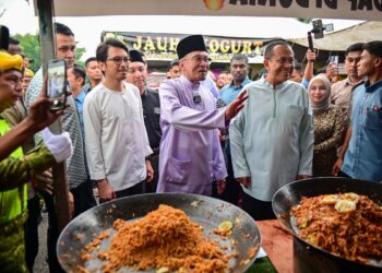 ANWAR Ibrahim dan Ahmad Samsuri Mokhtar menyantuni para peniaga dan pengunjung semasa melawat Bazar Ramadan Jalan Padang Astaka di Kemaman, Terengganu, hari ini.