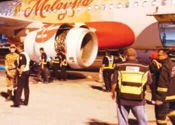 ANGGOTA bomba dan pasukan keselamatan memeriksa pesawat milik AirAsia selepas melakukan pendaratan cemas di Lapangan Terbang Antarbangsa Kuala Lumpur (KLIA) 2, semalam. – BOMBA