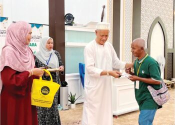 CHE Ibrahim Che Ismail menyampaikan sumbangan zakat kepada penerima di Masjid Ibrahim, Hentian Gua Musang, Kelantan. 
– UTUSAN/AIMUNI TUAN LAH