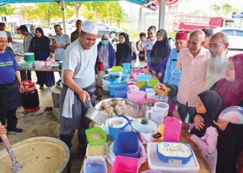 ROHAIMI Rashid mengagihkan bubur lambuk ‘gear box’ Pok Cik Abas kepada orang ramai  di Pasar Tani Ladang Hiliran, Kuala Terengganu semalam. – MINGGUAN/PUQTRA HAIRRY