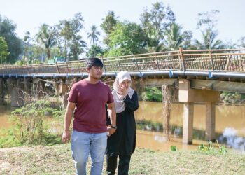 SURAIYA Izzaty (kanan) tidak dapat menahan sebak ketika mengunjungi semula lokasi jasad bapanya dipercayai dicampak di Sungai Derang, Jitra, Kedah. – UTUSAN/SHAHIR NOORDIN