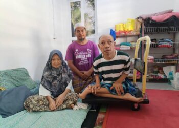 NOOR Izam Ahmad (tengah) menjaga kebajikan Bidin Ariffin (kanan) yang cacat di bahagian lutut dan kedua-dua belah kaki di Felda Sungai Tekam di Jerantut, Pahang. - MINGGUAN/HARIS FADILAH AHMAD