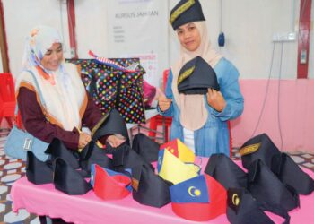 NORKINTAN Abdul Rahman (kanan) menunjukkan tanjak yang dihasilkannya di Felda Jengka 1 di Maran, Pahang. – UTUSAN/SALEHUDIN MAT RASAD