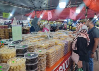 NUR Batrisyia Alya Mohd Ali masih berniaga kuih raya milik keluarganya secara fizikal di Bazar Aidilfitri Dataran Jam Besar, Sungai Petani, Kedah.