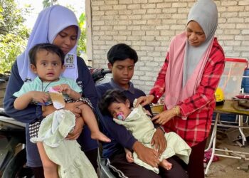 MUHAMMAD Azrul Hafizi bersama Aina Damia, Nur Qaseh Melissa dan Nur Chinta Melissa di samping ibu saudara mereka, Zuraina Abu di Kampung Tanjung Musang, Pokok Sena, Kedah.