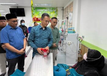 MOHAMAD Abdul Hamid (berdiri, dua dari kanan) berbual bersama seorang pesakit yang sedang menjalani rawatan dialisis di George Town, Pulau Pinang semalam.