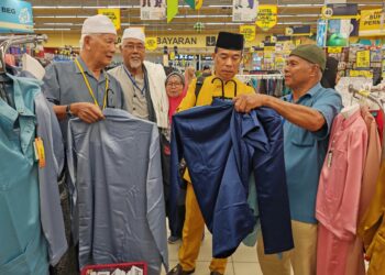 MOHAMAD Fazil Shafie (dua dari kanan) menyantuni sebahagian veteran ATM pada majlis sumbangan baju raya di Ayer Keroh, Melaka, semalam. - UTUSAN/AMRAN ALI
