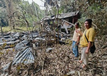 MOHD. Nor Rosmaini Mohd. Duni (kanan) dan Mohamad Azni menunjukkan rumah Zahari Ibrahim yang musnah terbakar di Kampung Kuala Semantan, Cheroh di Raub, Pahang hari ini. - UTUSAN/NORFARHIZA MOHD. ATAR