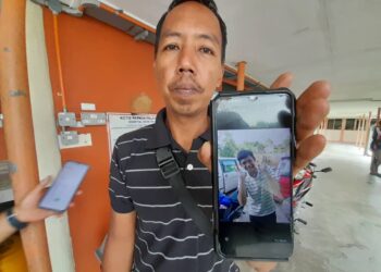 ZULKEPLY Ayob menunjukkan gambar Muhammad Aiman Amirul yang maut dalam kemalangan di Kilometer 19.3, Jalan Sungai Rengit-Kota Tinggi malam tadi.
