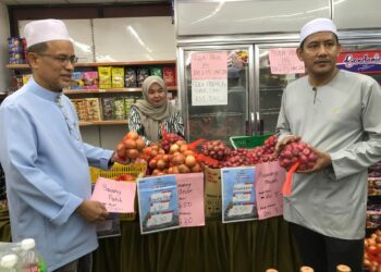AZMAN Ismail (kiri) memeriksa barangan keperluan sempena jualan Rahmah di sebuah kedai berhampiran pejabat KPDN Kelantan di Kota Bharu, Kelantan hari ini.- UTUSAN/ROSLIZA MOHAMED.