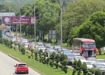 ALIRAN trafik semakin perlahan susulan pertambahan kereta
perantau semasa melalui lampu isyarat di Persimpangan Bendahara, Bandar Gua Musang.-UTUSAN/AIMUNI TUAN LAH.