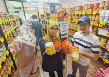 AZIE Izhar bersama Azley Alias menunjukkan sebahagian kuih raya yang terdapat di Syurga Cookies Homemade di Jalan Keretapi Lama, Kampung Gangsa, Melaka. – UTUSAN/AMRAN ALI