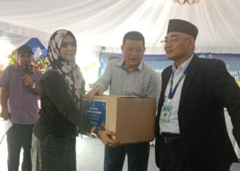 SIM Chon Siang (tengah) menyampaikan barang keperluan dapur kepada seorang penerima sempena pembukaan pasar raya kedua BS Freshmart di Bandar Baru Jerantut di Jerantut, Pahang.