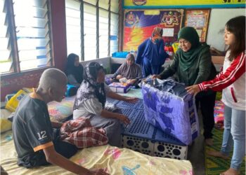 PENGERUSI  Jawatankuasa Pembangunan Wanita, Keluarga dan Masyarakat Negeri Johor, Khairin-Nisa Ismail (dua, kanan) menyampaikan bantuan kepada mangsa banjir yang ditempatkan di PPS Sekolah Kebangsaan Taman Molek, Johor Bahru.