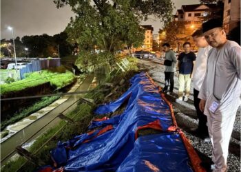 Pengerusi Jawatankuasa Perumahan dan Kerajaan Tempatan Johor, Datuk Mohd. Jafni Md. Shukor (kanan) meninjau kawasan kejadian tanah mendap di Bandar Baru Uda, Johor Bahru yang berlaku akibat hujan lebat sejak beberapa hari lalu.
