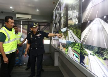MOHAMMAD Yusoff Abustan melihat paparan skrin LED keadaan trafik di Pusat Kawalan Terowong Meru Menora di Ipoh hari ini. - UTUSANMUHAMAD NAZREEN SYAH MUSTHAFA