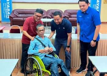 MOHD. Sanusi  Husain (kerusi roda) semasa menerima sumbangan  Yayasan Bank Rakyat (YBR) di Pasir Puteh, Kelantan. – UTUSAN/TOREK SULONG