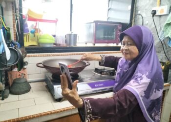 NARIAH Ahmad sedang berinteraksi dengan para pengikut media sosial di dapur rumahnya di Flat Kampung Melayu, George Town, Pulau Pinang.-UTUSAN/SAFINA RAMLI