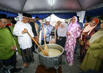 MOHAMAD Sabu (tengah) mengacau bubur lambuk pada Program Bersama Pimpinan Peladang Negeri Perak di PPK Tapah hari ini. - UTUSAN/MUHAMAD NAZREEN SYAH MUSTHAFA