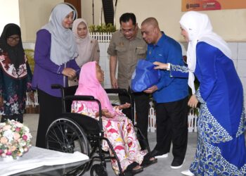 SAARANI Mohamad menyampaikan sumbangan bakul makanan kepada penerima pada Program Santunan Kasih Kerajaan Negeri Perak di Air Kuning di Tapah hari ini. - UTUSAN/ZULFACHRI ZULKIFLI