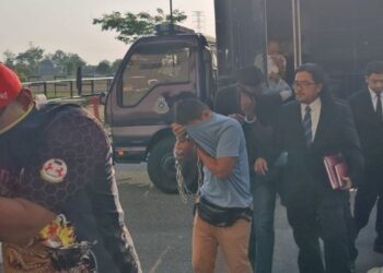 DUA anggota polis antara yang didakwa atas pertuduhan memiliki 240,000 mercun bola diiringi peguam ketika tiba di Kompleks Mahkamah Kangar, Perlis, hari ini. - UTUSAN/SYED AZLAN SAYID HIZAR